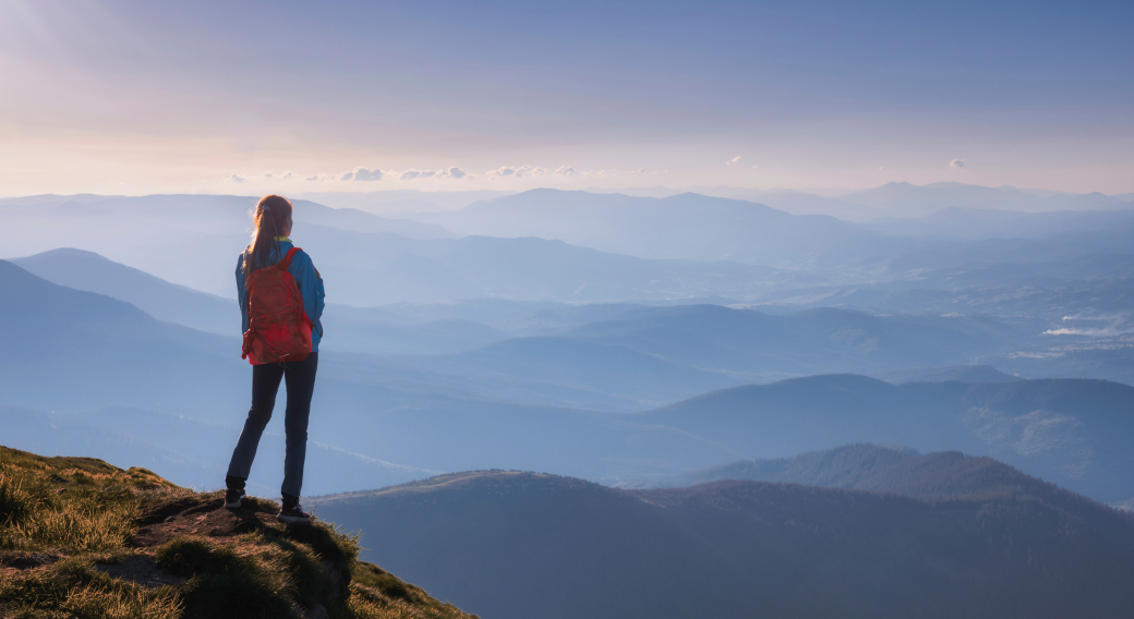 Mujer en la cima de una montaña, admirando el paisaje